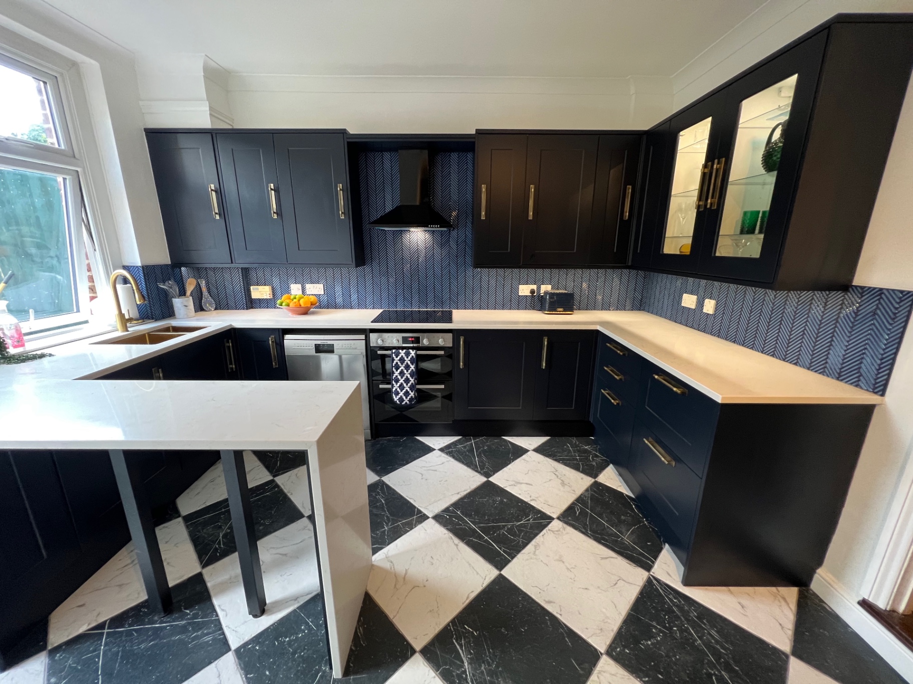 Peninsula seating area with quartz worktop and navy cabinetry
