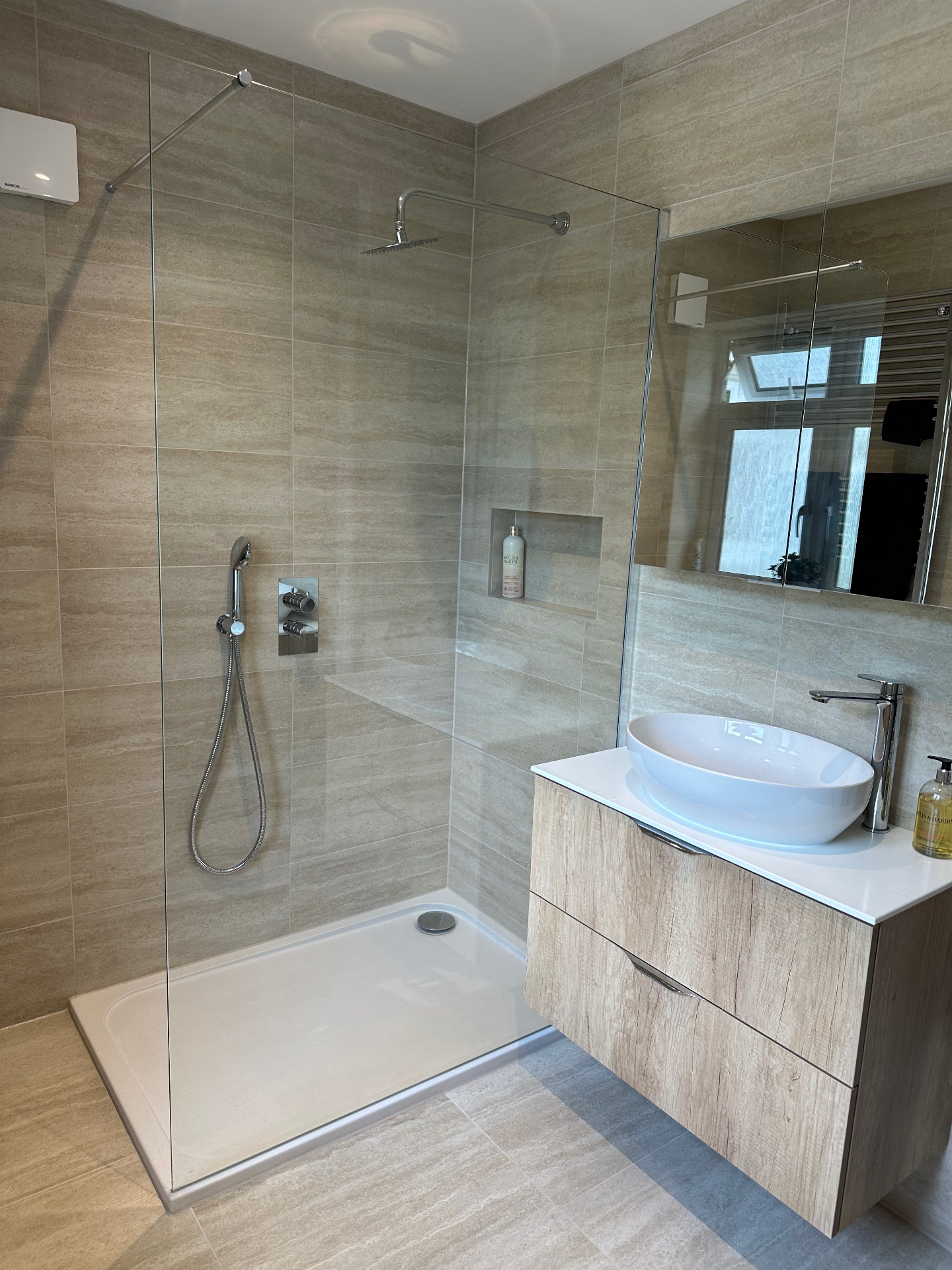Walk-in shower and wall-mounted vanity showing the relationship between the two areas