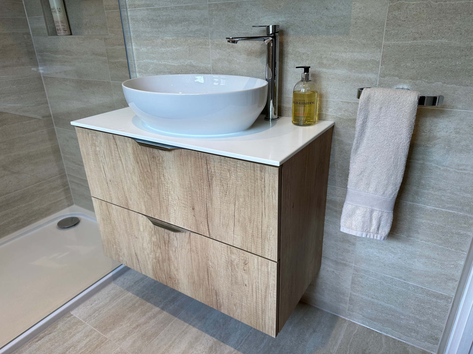Floating vanity detail with countertop basin, chrome tap and towel ring