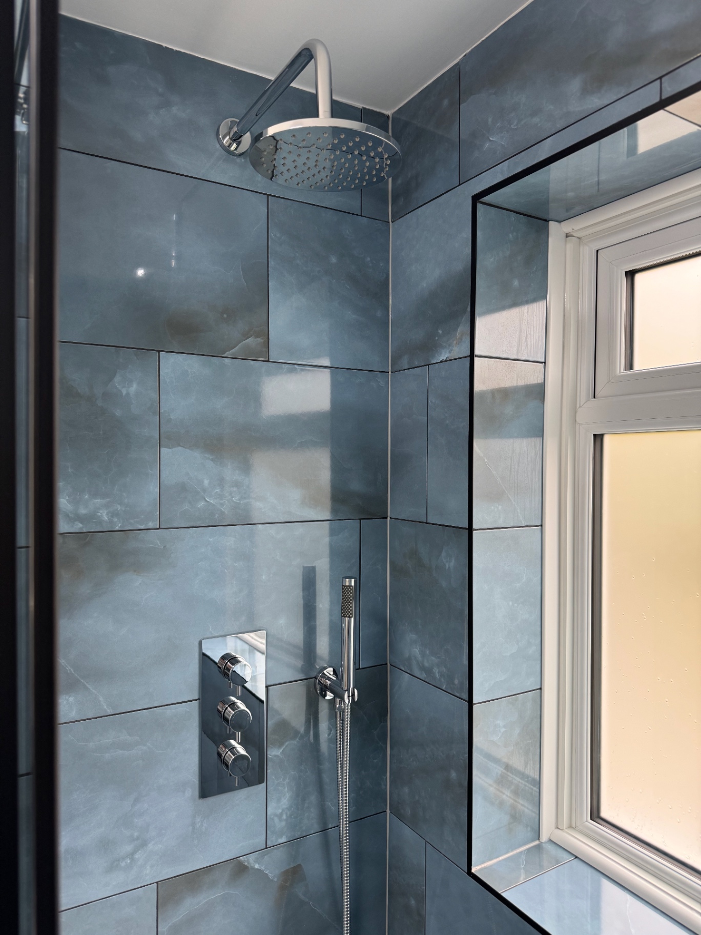 Rainfall shower head, hand shower and concealed thermostatic controls within the tiled enclosure