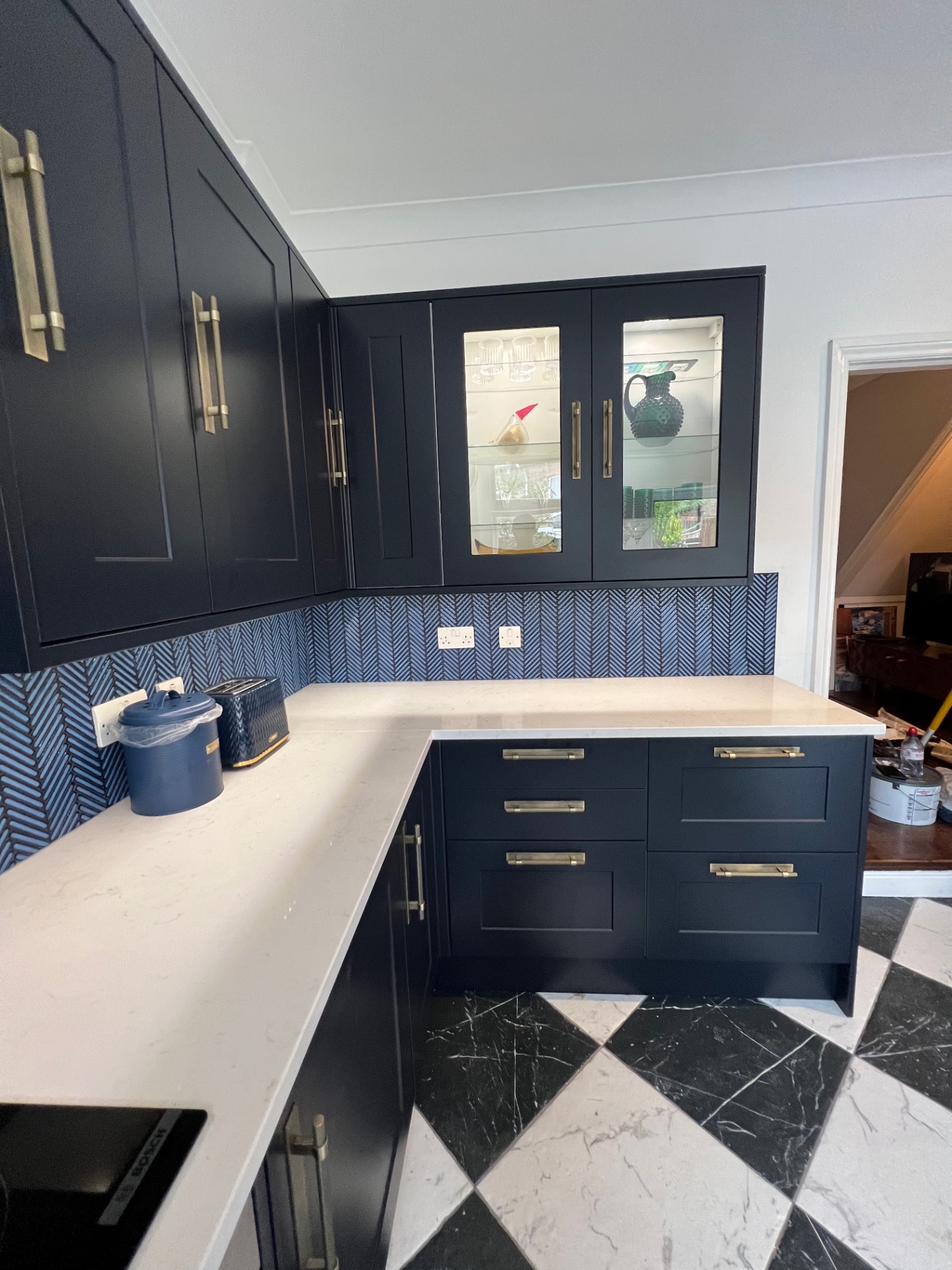Feature glazed wall cabinetry with brass handles above the quartz worktop