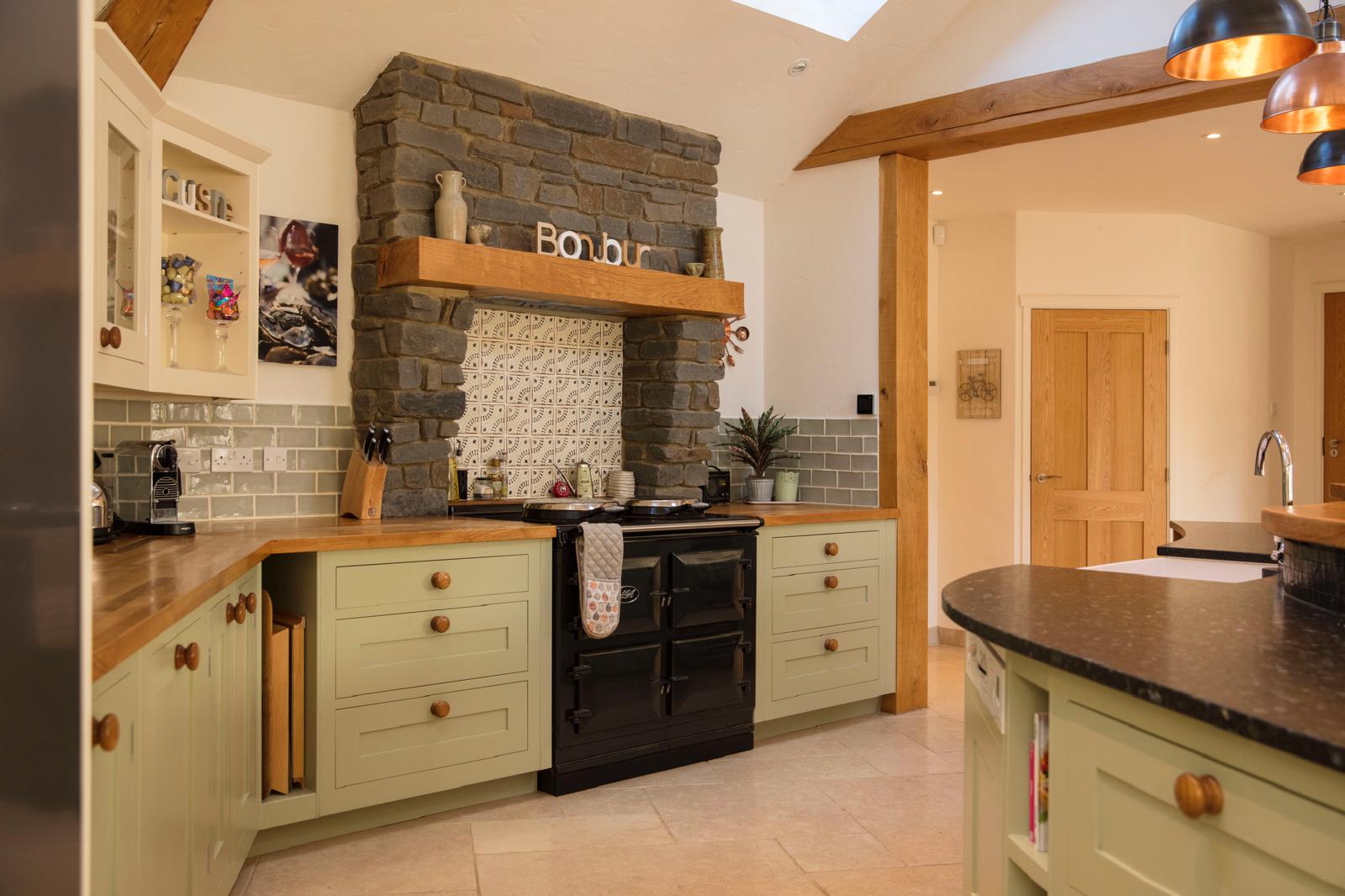 Range cooker set within a stone chimney breast with oak mantel