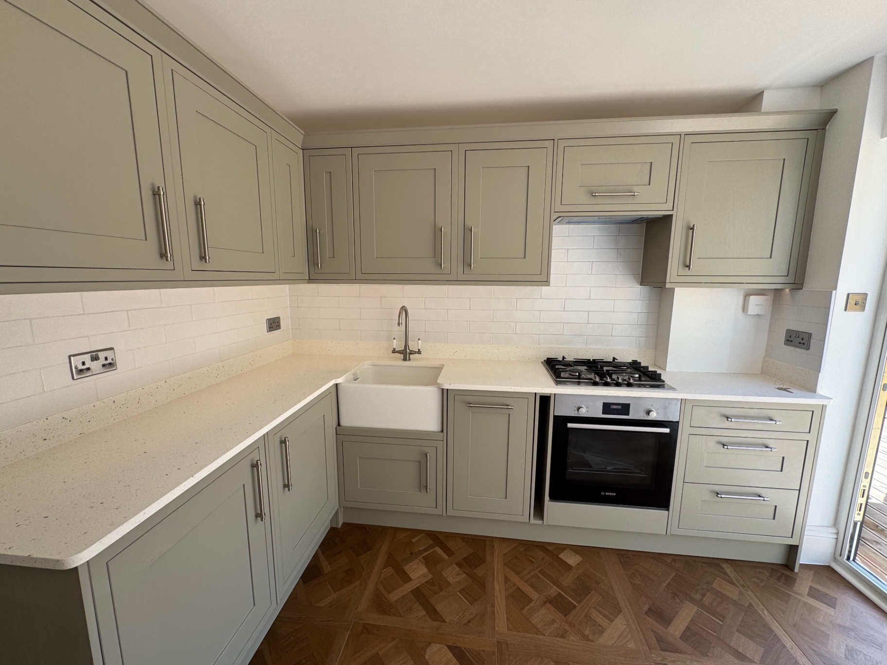 Kitchen from the opposite corner showing full run of cabinetry and appliances